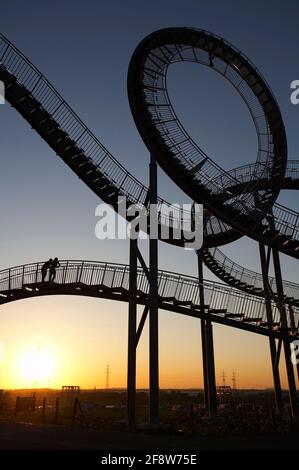 DEU, Deutschland, Duisburg, 24.05.2012: Ein junges Paar genießt den Sonnenuntergang auf der begehrbaren Skulptur TIGER & TURTLE - MAGIC MOUNTAIN von He Stockfoto