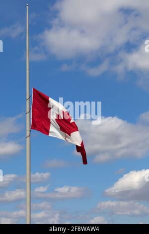 Kanadische Ahornblatt-Flagge auf Fahnenmast, die am Halbmast fliegt. Stockfoto