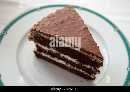 Schokoschwamm, Tortenscheibe aus nächster Nähe. Ansicht von der Seite und von oben auf einen Schokoladenkuchen auf einem Teller. Stockfoto