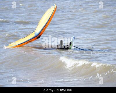 Sheerness, Kent, Großbritannien. April 2021. UK Wetter: Sonnig in Sheerness, Kent. Ein Mann versucht die neue Sportart der Tragflügeldrachen oder des "Flügelsurfens" oder "Flügelfolierung" - ein Hydrofoil-Board mit einem kleinen Drachen, den man direkt hält - anstatt die Kontrolle über mehrere Saiten und ein Geschirr wie beim traditionellen Kitesurfen zu haben. Kredit: James Bell/Alamy Live Nachrichten Stockfoto