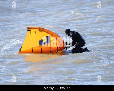 Sheerness, Kent, Großbritannien. April 2021. UK Wetter: Sonnig in Sheerness, Kent. Ein Mann versucht die neue Sportart der Tragflügeldrachen oder des "Flügelsurfens" oder "Flügelfolierung" - ein Hydrofoil-Board mit einem kleinen Drachen, den man direkt hält - anstatt die Kontrolle über mehrere Saiten und ein Geschirr wie beim traditionellen Kitesurfen zu haben. Kredit: James Bell/Alamy Live Nachrichten Stockfoto