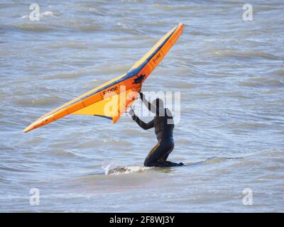 Sheerness, Kent, Großbritannien. April 2021. UK Wetter: Sonnig in Sheerness, Kent. Ein Mann versucht die neue Sportart der Tragflügeldrachen oder des "Flügelsurfens" oder "Flügelfolierung" - ein Hydrofoil-Board mit einem kleinen Drachen, den man direkt hält - anstatt die Kontrolle über mehrere Saiten und ein Geschirr wie beim traditionellen Kitesurfen zu haben. Kredit: James Bell/Alamy Live Nachrichten Stockfoto