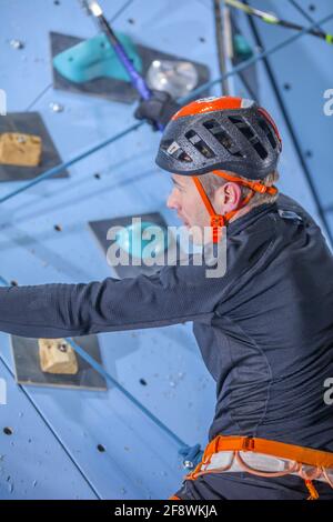 Slowenischer sportlicher Mann, der am Kunstfelsen klettert Stockfoto