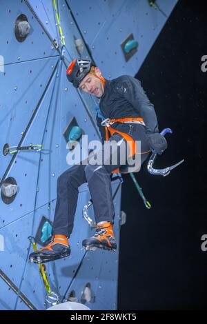 Slowenischer sportlicher Mann, der am Kunstfelsen klettert Stockfoto