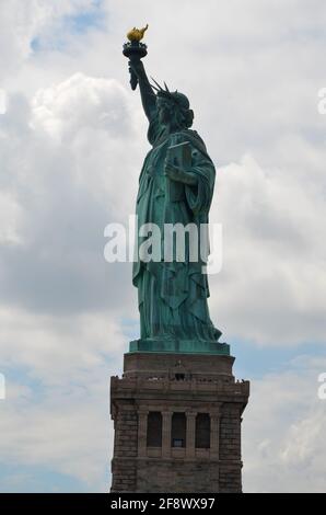 Die Freiheitsstatue auf Liberty Island bei wolkiger Sonne Himmel Stockfoto