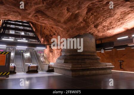 Stockholm, Schweden Juni 7 2019: Unterirdische U-Bahn-Station Tunnelbana Radhuset mit Rolltreppe und orange-braun gemusterten Höhlen Wände und Decke Stockfoto