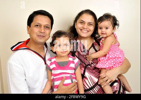 Mumbai, Maharashtra, India- Asia, Nov. 27; 2011- Indian Happy Family Eltern mit 4 Jahren und drei Monaten zwei süße kleine Mädchen lächeln. Stockfoto