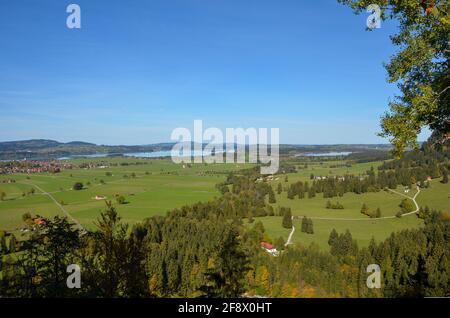 Blick vom Schloss Neuschwanstein auf die dahinterliegende flache Seenplatte Mit einem sonnigen, klaren blauen Himmel Stockfoto