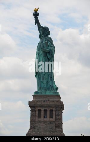 Die Freiheitsstatue auf Liberty Island bei wolkiger Sonne Himmel Stockfoto