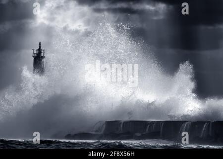 Große Sturmwelle gegen den Leuchtturm von Vila do Conde, nördlich von Portugal (verstärkter Himmel). Blau getönt. Stockfoto