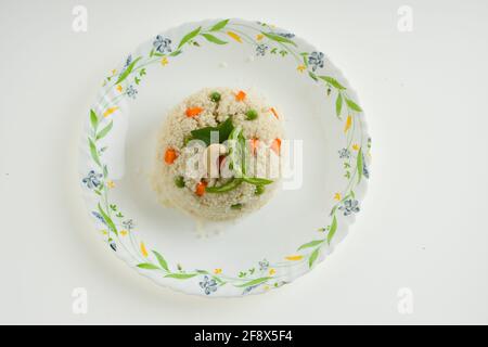 UPMA aus Samolina oder rava Upma, dem berühmtesten südindischen Frühstückselement, das wunderschön auf einem Teller arrangiert und mit gebratenem Cashew garniert ist Stockfoto