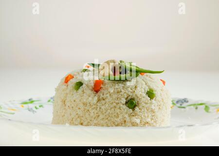 UPMA aus Samolina oder rava Upma, dem berühmtesten südindischen Frühstückselement, das wunderschön auf einem Teller arrangiert und mit gebratenem Cashew garniert ist Stockfoto