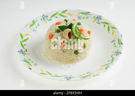 UPMA aus Samolina oder rava Upma, dem berühmtesten südindischen Frühstückselement, das wunderschön auf einem Teller arrangiert und mit gebratenem Cashew garniert ist Stockfoto