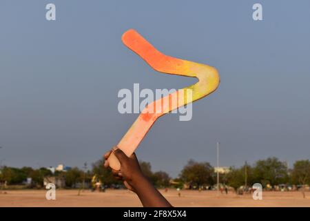 boomerang in Jungen Hand über blauen Himmel Hintergrund Stockfoto