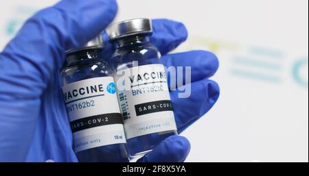 Odessa, Ukraine - 9. Dezember 2020: Wissenschaftler oder Arzt in Gummihandschuhen hält neuen BNT162b2-Impfstoff zur Injektion von menschlichen Freiwilligen gegen SARS-Cov bereit Stockfoto
