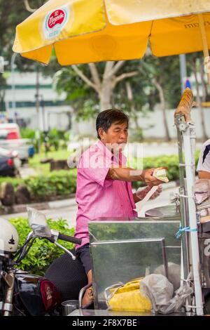 Singapur, Singapur - 4. Januar 2014: Ein Straßenverkäufer, der Eisdielen in einer Straße in Singapur verkauft. Stockfoto