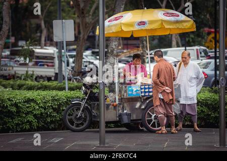 Singapur, Singapur - 4. Januar 2014: Zwei Mönche kaufen Eis-Sandwich von einem Straßenhändler. Stockfoto