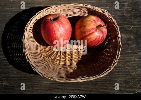Zwei Äpfel in einem Korb auf einem Holztisch Stockfoto