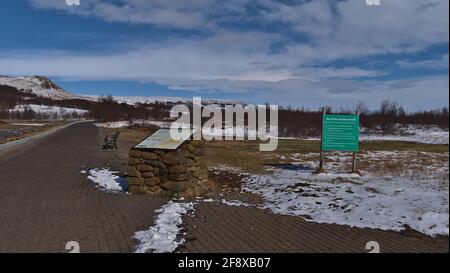 Informations- und Warnschilder am Eingang des Geysir Geothermie-Feldes in Haukadalur, Teil des Goldenen Kreises, in der Wintersaison mit Pfad und Schnee. Stockfoto