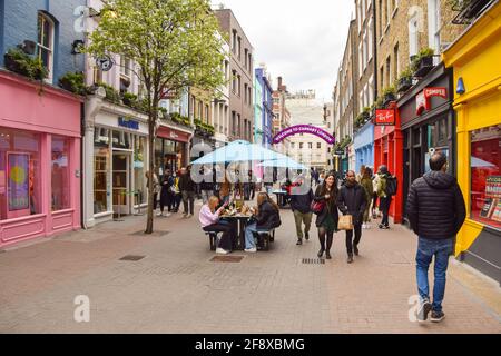 London, Großbritannien. April 2021. Eine geschäftige Carnaby Street im Zentrum von London. Geschäfte, Restaurants, Bars und andere Unternehmen öffneten nach fast vier Monaten wieder, da sich die weiteren Sperrregeln in England lockern. Stockfoto
