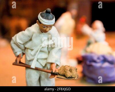 Diorama eines Mannes, der Schmutz schaufelt und die Tonvasen für Kimchi bedeckt. Im Kimchi Field Museum in Seoul, Südkorea. Stockfoto