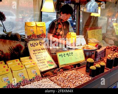 Ein typischer, lokaler, traditioneller Verkäufer in einem kleinen Pop-up-Stand, der getrocknete Nüsse verkauft. In Seoul, Südkorea. Stockfoto