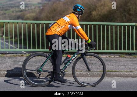 Männlicher Radfahrer fährt De Rosa Super HM Composite hochfeste aerodynamische und schnelle Sport-Rennrad auf Landstraße über Autobahnbrücke im ländlichen Lancashire, Großbritannien Stockfoto