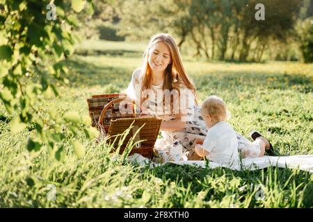 Glückliche Eltern Mama und Tochter beim Picknick gehen im Sommer im Park spazieren. Stockfoto