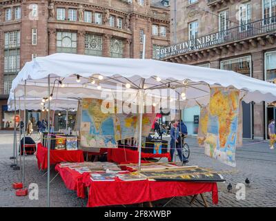 Junge schöne Mädchen trägt eine Atemmaske nähert sich dem Markt Stall, der alte Karten verkauft Stockfoto