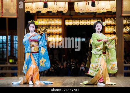 Geisha trägt Kimono, tanzt und tritt vor Publikum auf der Bühne auf. Schöne und elegante Maiko. Yasaka-Schrein, Kyoto, Japan. Stockfoto