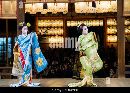 Geisha trägt Kimono, tanzt und tritt vor Publikum auf der Bühne auf. Schöne und elegante Maiko. Yasaka-Schrein, Kyoto, Japan. Stockfoto