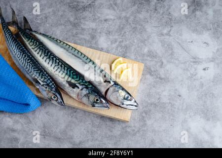 Makrele auf Holzhintergrund auf Marmorhintergrund. Speicherplatz kopieren. Konzept für frischen Fisch. Stockfoto