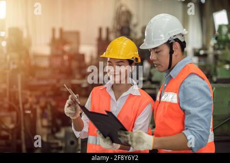 Zwei Ingenieure und Frauen arbeiten zusammen, asiatische junge Menschen arbeiten als Teamarbeit helfen zusammen glückliches Lächeln in der Fabrik Schwerindustrie zu unterstützen Stockfoto