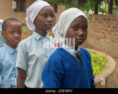 Dodoma, Tansania. 08-18-2019. Porträt von drei muslimischen schwarzen Mädchen, die Schlange stehen, um ihr Mittagessen zu bekommen, nachdem die Schule in einem abgelegenen Dorf beendet ist Stockfoto