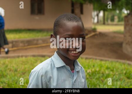 Dodoma, Tansania. 08-18-2019. Porträt eines lächelnden schwarzen muslimischen Jungen während einer Klassenpause während der Schulstunden in einem abgelegenen Dorf in Tansania. Stockfoto