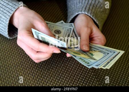 Kaukasische Frauenhände zählen Dollarnoten. Frau hält Geld Währung der Vereinigten Staaten. Nahaufnahme. Selektiver Fokus. Stockfoto