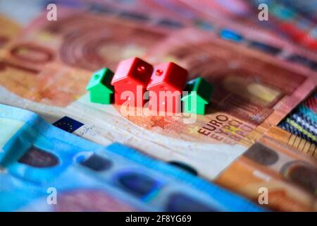 Tisch mit Euro-Banknoten bedeckt mit Häusern auf der Oberseite. Immobilieninvestitionskonzept Stockfoto