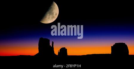 Mond bei Sonnenaufgang über Silhouetten von Mitten Buttes und Merrick Butte, Monument Valley, Arizona, USA Stockfoto