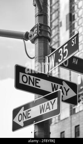 Schwarz-Weiß-Bild von Einbahnstraßen-Schildern in der West 35th Street in New York City, USA. Stockfoto