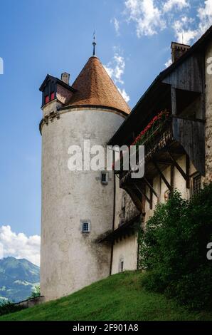 Außenansicht des Dorfes Gruyeres, berühmte Käserei Stadt der schweiz. Detail seiner mittelalterlichen Burg mit bewölktem Hintergrund Stockfoto