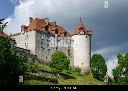 Außenansicht des Dorfes Gruyeres, berühmte Käserei Stadt der schweiz. Detail seiner mittelalterlichen Burg mit bewölktem Hintergrund Stockfoto