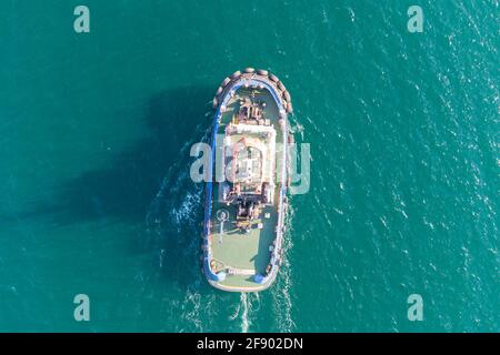 Der Seeschlepper bewegt sich vom Hafengebiet in Richtung offenes Meer. Foto aus dem Hubschrauber. Blick von oben Stockfoto