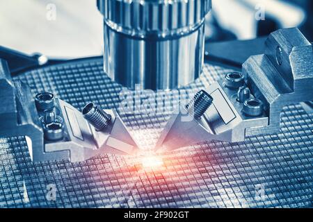 Nahaufnahme der Untersuchung der Testprobe des Mikrochip-Transistors unter dem Mikroskop im Labor. Ausrüstung zum Testen von Mikrochips. Automatisierung von Produ Stockfoto