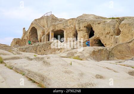 Besucher, die die antike Uplistsikhe Cave City auf den Rocky erkunden Massiv der Region Shida Kartli in Georgien Stockfoto