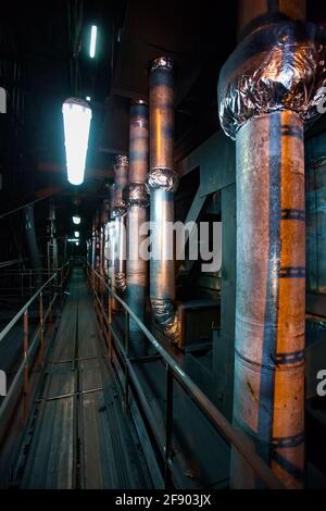 Dampfkraftwerk. Blick auf Kesselrohre in Wärmedämmung. Brücke mit Geländer. Ekibastuz, Pawlodar-Region, Kasachstan. Kraftpaket GRES-1. Stockfoto