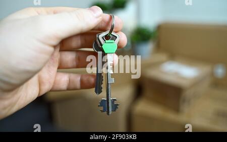 Mann mit Schlüsseln aus der neuen Wohnung. Erfolgreicher Umzug in eine neue Wohnung. Stockfoto