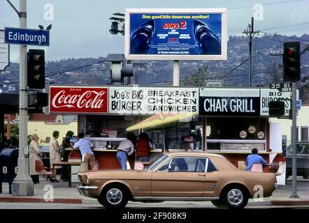 Ein klassischer Ford Mustang aus dem Jahr 1965 passiert vor Joe's Big Burger in Edinburgh und in der 3rd Street in der Nähe des Farmers Market in Los Angeles, CA Stockfoto