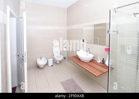 Kleines aber luxuriöses Badezimmer, Spiegel, weiße Fliesen, Waschbecken, Toilette Stockfoto