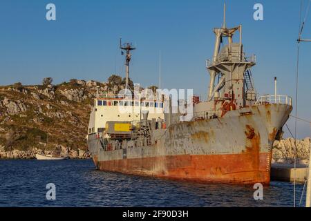 Auf dem Pier steht ein eisernes altes Marineschiff bedeckt In Rost Stockfoto