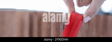 Weibliche Hand, die roten Holzblock aus der Linie Nahaufnahme herauszieht Stockfoto
